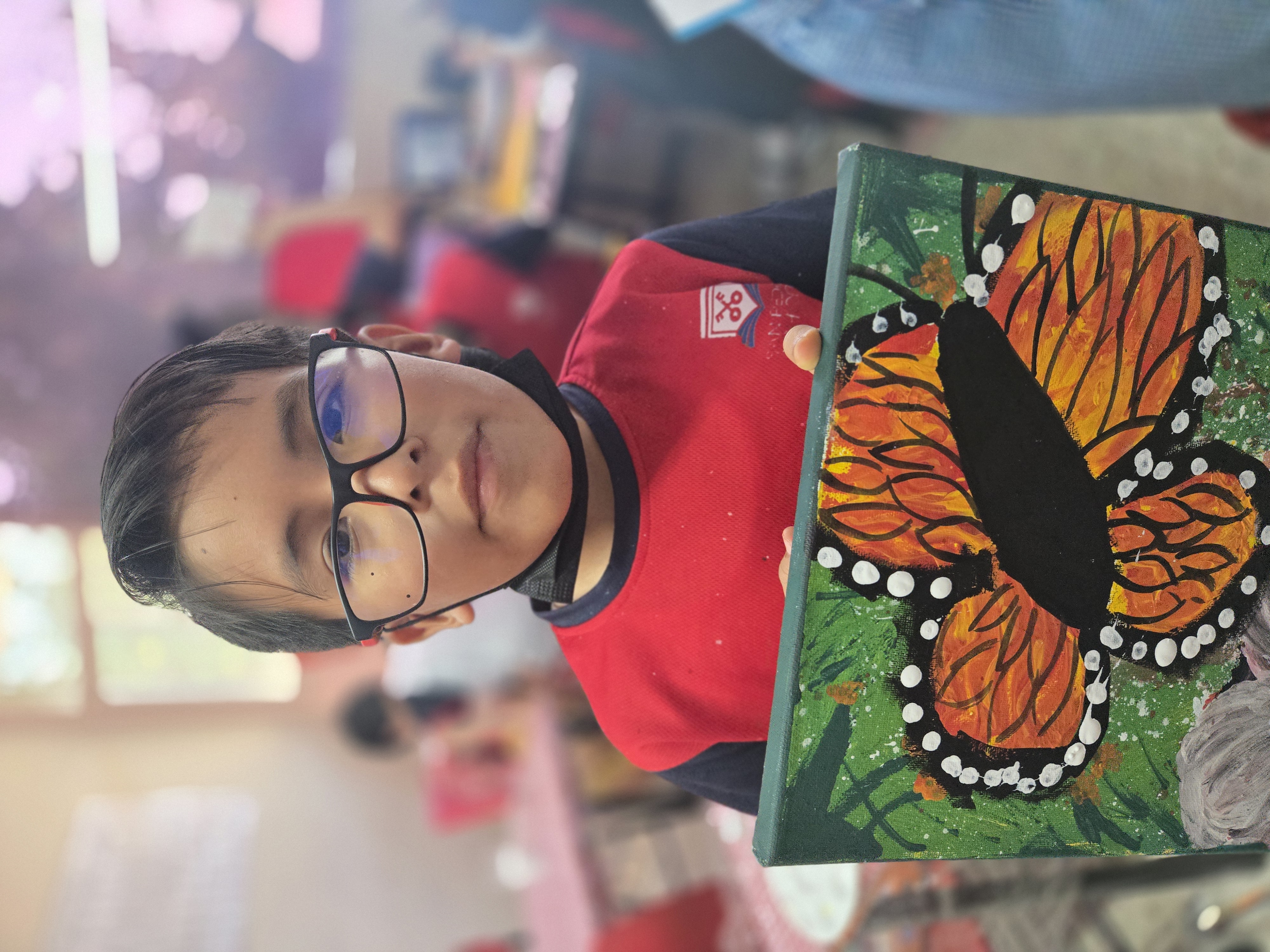 Alumno de San Pedro School mostrando una obra artística
